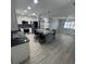 Bright, open kitchen features a large island with marble countertop, stainless steel appliances, and gray vinyl plank flooring at 732 Palma Dr, Lady Lake, FL 32159