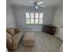 Cozy living room with a beige couch, light gray flooring, and a window with white shutters at 732 Palma Dr, Lady Lake, FL 32159