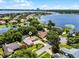 Expansive aerial view of a lakeside home with a pool, lush landscaping, and stunning views of the surrounding lake and city skyline at 8625 Vista Point Cv, Orlando, FL 32836