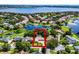Beautiful aerial view of a lakeside home surrounded by mature trees, other homes, and a sparkling lake in a waterfront community at 8625 Vista Point Cv, Orlando, FL 32836