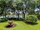 Lush backyard with a bird bath, flowers, mature trees, and a partial view of the waterfront at 8625 Vista Point Cv, Orlando, FL 32836