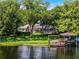 Serene waterfront view of a home's backyard, featuring a private dock, boat lift, and lush landscaping at 8625 Vista Point Cv, Orlando, FL 32836