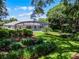 Manicured backyard with lush landscaping, featuring a screened-in pool, and a neatly trimmed lawn at 8625 Vista Point Cv, Orlando, FL 32836