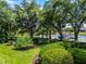 Beautifully landscaped backyard featuring mature trees, lush lawn, and a glimpse of the waterfront at 8625 Vista Point Cv, Orlando, FL 32836