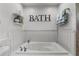 Cozy soaking tub surrounded by white wood panels in a well-lit bathroom at 8625 Vista Point Cv, Orlando, FL 32836