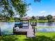 Dock on a waterfront property, featuring a boat lift, covered seating area, and views of neighboring homes at 8625 Vista Point Cv, Orlando, FL 32836