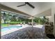 Large screened in pool patio with brick pavers, ceiling fan, outdoor kitchen, dining area, and view of the lake at 8625 Vista Point Cv, Orlando, FL 32836