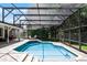 A screened-in pool with blue tile and outdoor seating areas at 8625 Vista Point Cv, Orlando, FL 32836