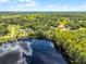 Stunning aerial view of the property with a lake, trees, and lush green surroundings at 9642 Florida Boys Ranch Rd, Clermont, FL 34711