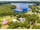Aerial view of the property showcasing its proximity to a beautiful lake and surrounded by lush greenery and trees at 9642 Florida Boys Ranch Rd, Clermont, FL 34711