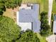 Aerial view of the home featuring a new roof, large concrete patio, and mature trees at 9642 Florida Boys Ranch Rd, Clermont, FL 34711