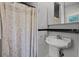 Classic bathroom features a floral shower curtain, pedestal sink, and black and white tile at 9642 Florida Boys Ranch Rd, Clermont, FL 34711