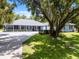 Charming single-story home with a large front yard, mature trees, and a long driveway leading to a three-car garage at 9642 Florida Boys Ranch Rd, Clermont, FL 34711