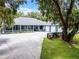Spacious single-story home with a covered front porch, three-car garage, and a large driveway, surrounded by mature trees at 9642 Florida Boys Ranch Rd, Clermont, FL 34711