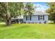 Well-maintained home with a sprawling front lawn, mature trees, and a driveway, offering a serene and welcoming atmosphere at 9642 Florida Boys Ranch Rd, Clermont, FL 34711