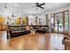 Open living room with hardwood floors, leather sofas, and lots of natural light from the doors and windows at 9642 Florida Boys Ranch Rd, Clermont, FL 34711