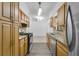 Galley kitchen featuring stainless steel appliances and view of the dining room and living room at 1148 Northcrest Dr, Apopka, FL 32703
