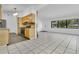 Open-concept living room and kitchen with tile floors and ample natural light from a large window at 1148 Northcrest Dr, Apopka, FL 32703