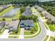 Aerial view of the home featuring a landscaped yard, community pond, and neighborhood streets at 11850 Sheltering Pine Dr, Orlando, FL 32836