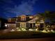Inviting two-story home featuring a well-manicured lawn, landscape lighting and a charming front porch under a cloudy blue sky at 11850 Sheltering Pine Dr, Orlando, FL 32836