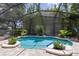 An inviting screened-in pool offers a refreshing retreat, surrounded by lush landscaping and a paver patio at 11850 Sheltering Pine Dr, Orlando, FL 32836