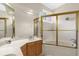 Bathroom with a large tub, tile surround, and gold framed glass shower doors at 1217 Salerno Ct # 1217, Orlando, FL 32806