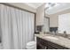Granite countertop vanity and shower-tub combo with patterned curtain in this well maintained bathroom at 1217 Salerno Ct # 1217, Orlando, FL 32806