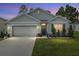 Charming single-story home with landscaped front yard at dusk at 133 Hickory Course Circle, Ocala, FL 34472