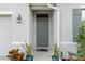 Inviting front entrance with a gray door and potted plants at 133 Hickory Course Circle, Ocala, FL 34472