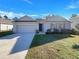 Charming single Gathering home featuring a well-manicured lawn and an attached two car garage at 133 Hickory Course Circle, Ocala, FL 34472