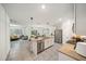 Open-concept kitchen with island and stainless-steel appliances, flowing into living area at 133 Hickory Course Circle, Ocala, FL 34472