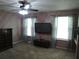 Cozy bedroom featuring a ceiling fan, mounted television, and neutral carpet at 1420 Center St, Ocoee, FL 34761