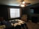 Dark bedroom with a ceiling fan, natural light, and comfortable seating at 1420 Center St, Ocoee, FL 34761