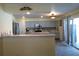 Open-concept kitchen featuring stainless steel appliances, light gray cabinetry, and sliding glass doors to the lanai at 1420 Center St, Ocoee, FL 34761