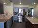 Modern kitchen with stainless steel refrigerator, tile flooring, marble countertops, and gray cabinetry at 1420 Center St, Ocoee, FL 34761