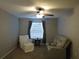Cozy sitting area featuring a recliner loveseat, a small table, and a white arm chair with ottoman at 1420 Center St, Ocoee, FL 34761
