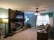 Comfortable living room features a stone fireplace, ceiling fan, and neutral-toned tile flooring at 1420 Center St, Ocoee, FL 34761