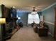 Cozy living room with stone fireplace, TV, ceiling fan, and comfortable seating by a window at 1420 Center St, Ocoee, FL 34761