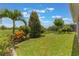 Spacious backyard featuring a lush lawn, black metal fence, mature trees and a palm tree at 15424 Sweet Orange Ave, Winter Garden, FL 34787