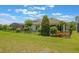 Expansive backyard featuring lush green lawn, black fencing, mature landscaping, and a screened-in lanai at 15424 Sweet Orange Ave, Winter Garden, FL 34787