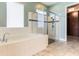 Elegant bathroom featuring a soaking tub and separate glass-enclosed shower, plus large walk-in closet at 15424 Sweet Orange Ave, Winter Garden, FL 34787