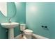 Comfortable half-bathroom featuring blue walls, pedestal sink, and toilet at 15424 Sweet Orange Ave, Winter Garden, FL 34787