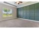 Spacious bedroom with a view of the outside and a feature accent wall at 15424 Sweet Orange Ave, Winter Garden, FL 34787