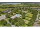 Aerial view of community: pool, dog park, and tennis courts amidst mature trees at 15424 Sweet Orange Ave, Winter Garden, FL 34787