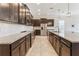 Modern kitchen with dark cabinets, stainless steel appliances, granite countertops and tiled backsplash at 15424 Sweet Orange Ave, Winter Garden, FL 34787