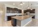 Open kitchen with dark wood cabinets, stainless steel appliances, granite countertops and large island at 15424 Sweet Orange Ave, Winter Garden, FL 34787