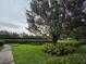 Lush landscaping with manicured hedges and a large shade tree in the well-maintained yard at 15424 Sweet Orange Ave, Winter Garden, FL 34787