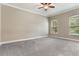 Large primary bedroom featuring carpet flooring, neutral walls, and windows overlooking the landscape at 15424 Sweet Orange Ave, Winter Garden, FL 34787