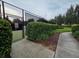 Tennis courts with a new fence, green hedges, and a well-maintained path, perfect for sports enthusiasts at 15424 Sweet Orange Ave, Winter Garden, FL 34787