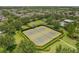 Aerial view of tennis courts surrounded by lush green landscaping in a residential community at 15424 Sweet Orange Ave, Winter Garden, FL 34787